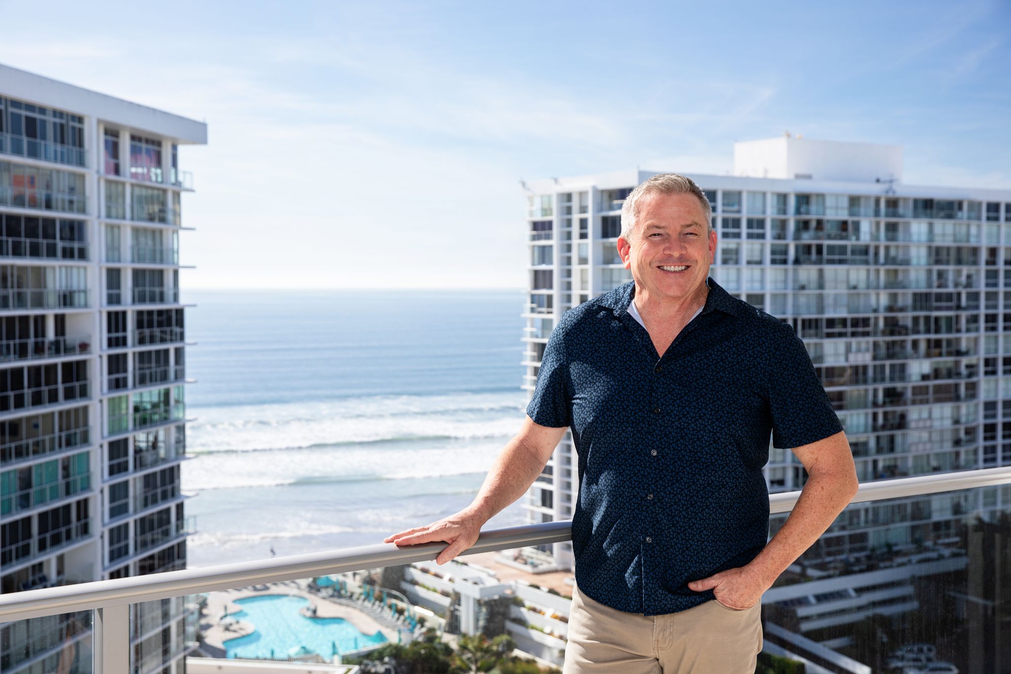 Tom Tilford standing on a Coronado Shores balcony overlooking the ocean
